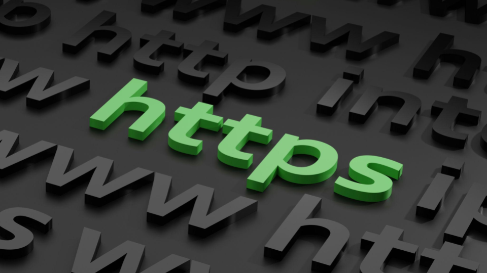 A sigla "https" se destaca em letras tridimensionais de cor verde-clara. Ela está posicionada ligeiramente em diagonal no centro da imagem. A cor verde é comumente associada à segurança, autenticidade e conexões seguras na internet.